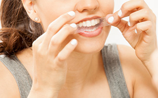 Woman placing teeth whitening strip