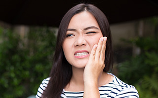 Woman holding jaw in pain