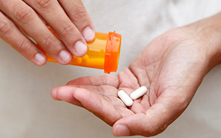 Hand holding antibiotic tablets