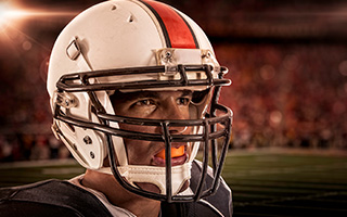 Man with football gear and orange mouthguard
