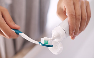 Toothpaste being put on toothbrush