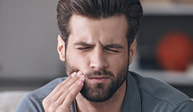 Man holding jaw in pain