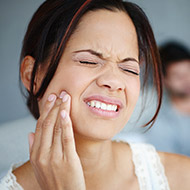 Woman holding jaw in pain