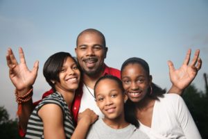 family of four hugging and laughing